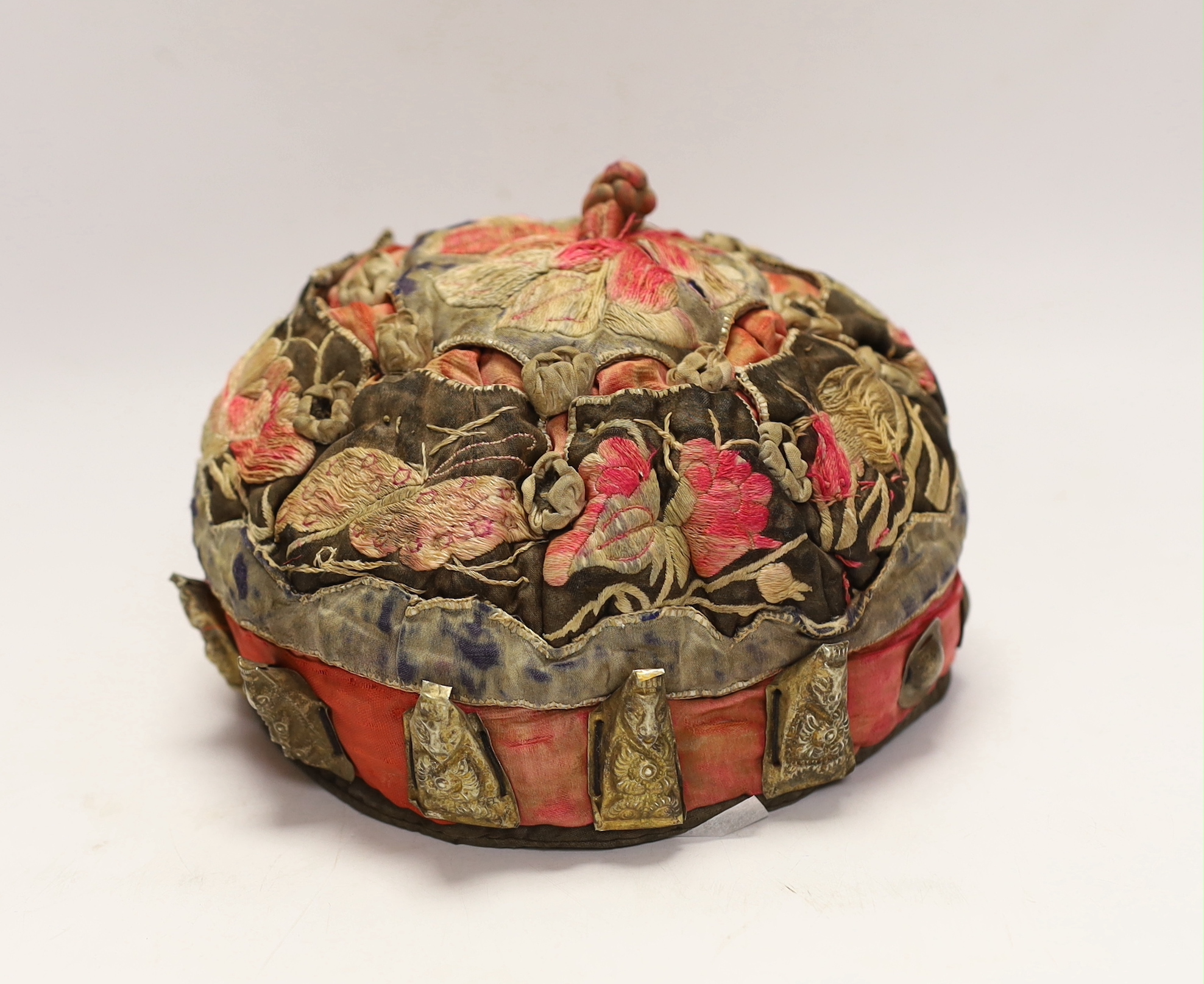 A Chinese metal mounted and embroidered skull cap